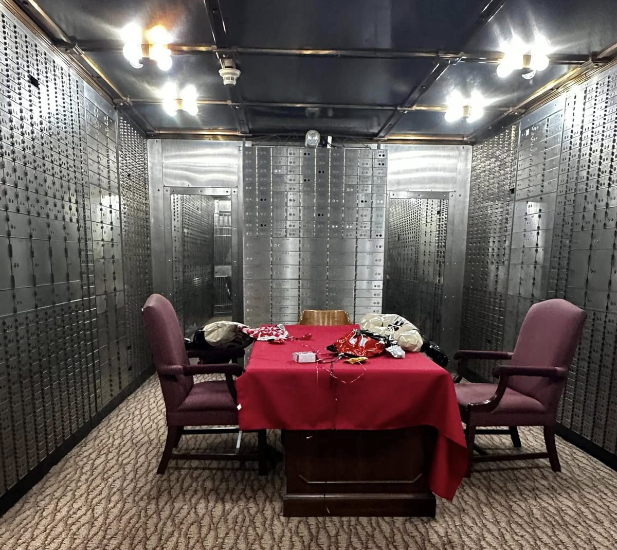 Inside the Mana Vault: a red-draped game table surrounded by walls of original safe deposit boxes