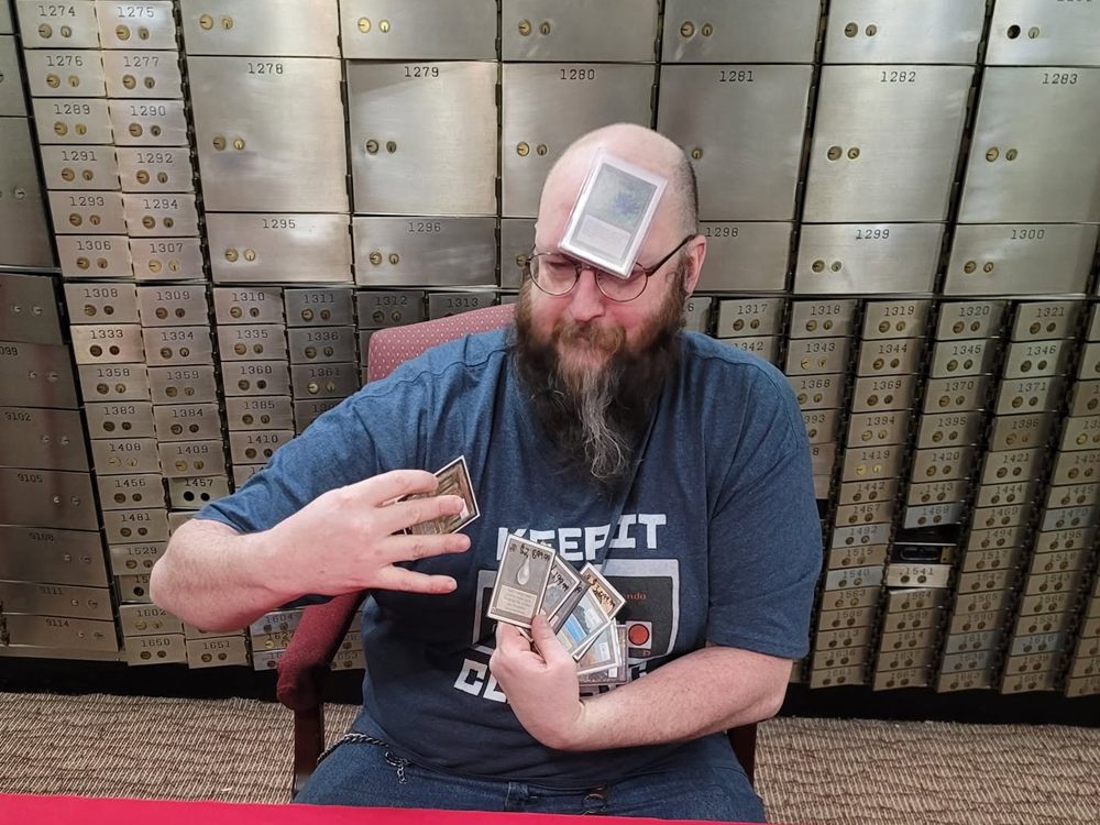Bodach showing off vintage Magic: The Gathering cards in front of the safe deposit boxes