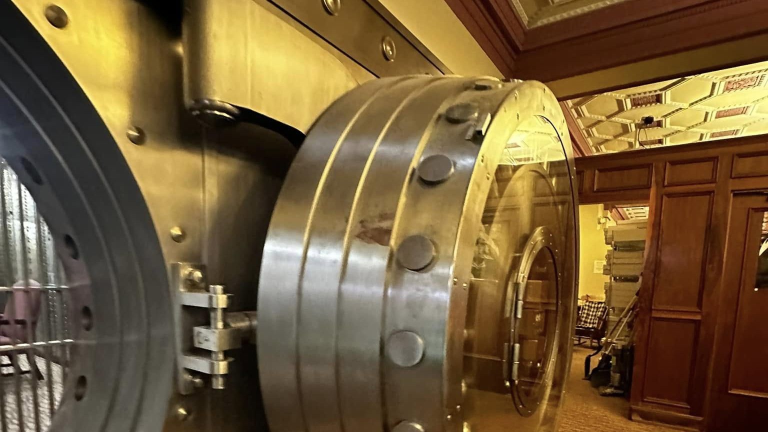 The massive round vault door swung open under the bank's ornate ceiling